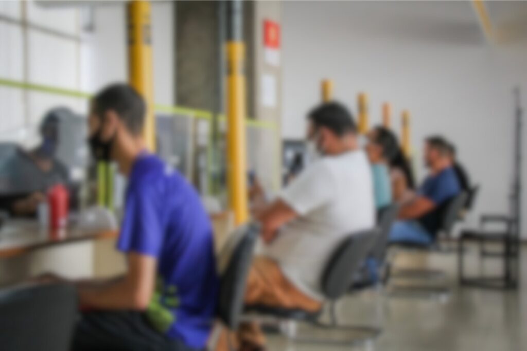 People wearing masks waiting in line indoors.