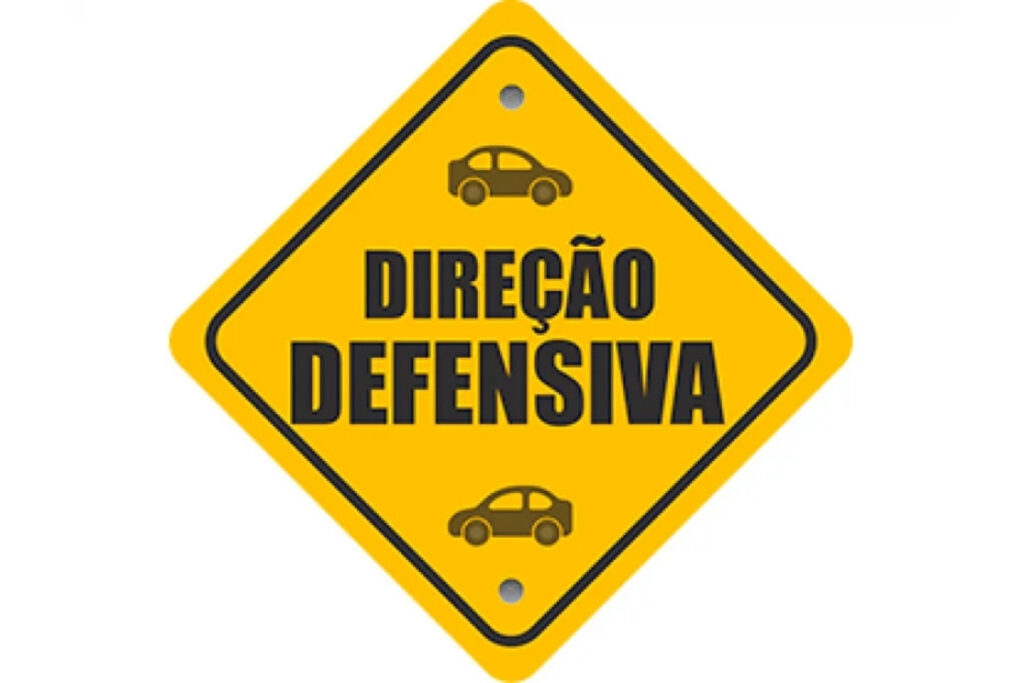 Yellow sign promoting defensive driving skills.